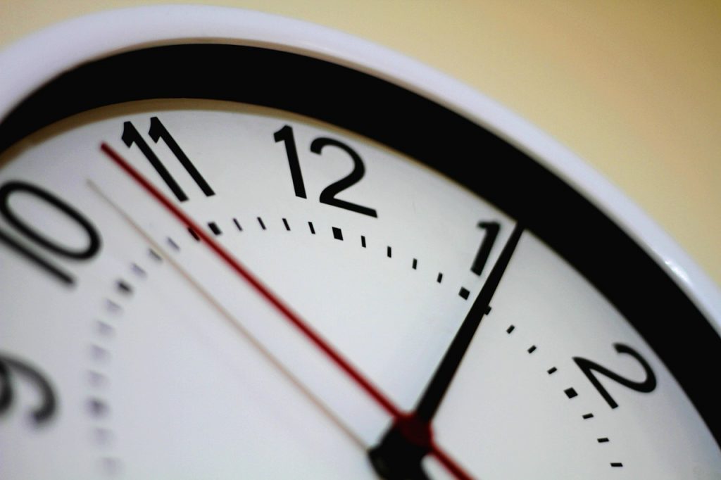 Há um relógio branco que sinaliza a importância de horários bem definidos.