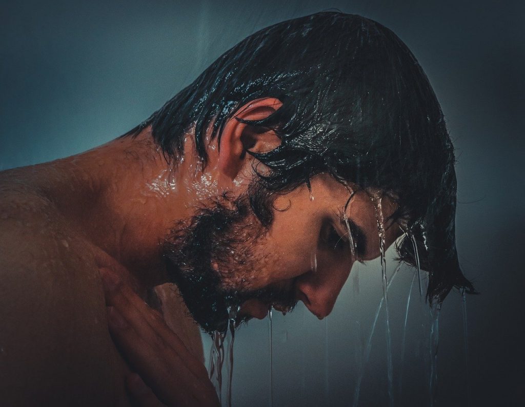 Homem com o cabelo molhado no banho.